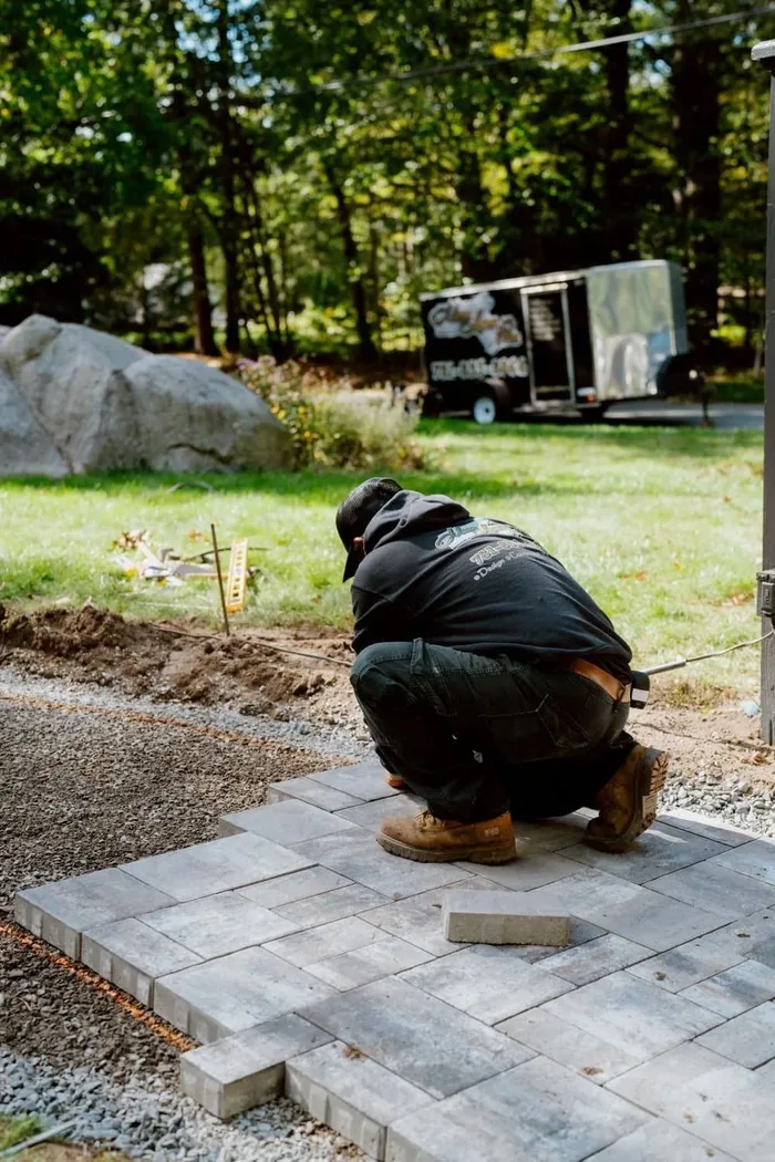 Crew member installing a paver patio walkway