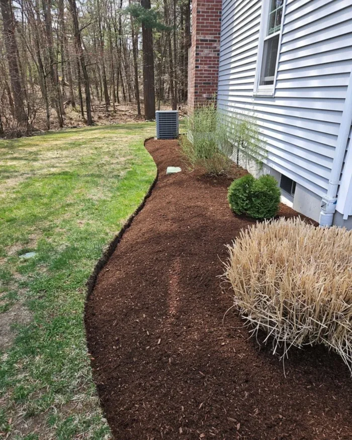 Freshly mulched planting bed along a home's foundation